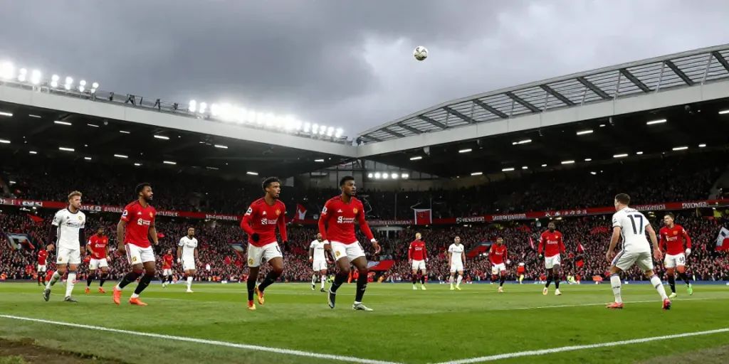 Exciting Manchester United vs Liverpool football match with intense players and passionate fans.